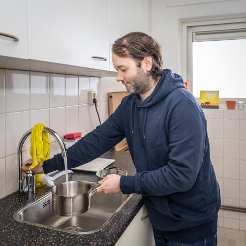 Man vult een pan met water